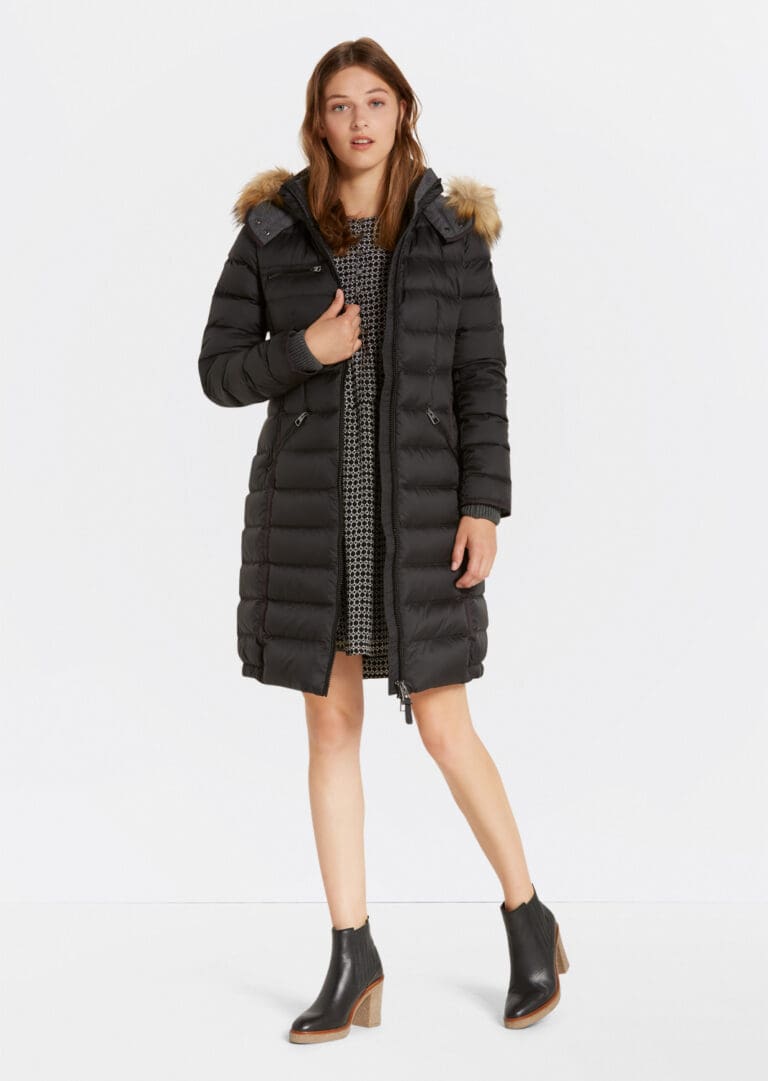 Woman modeling stylish black winter coat with fur hood