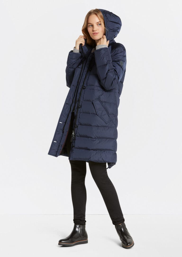 Woman posing in a long navy blue winter coat