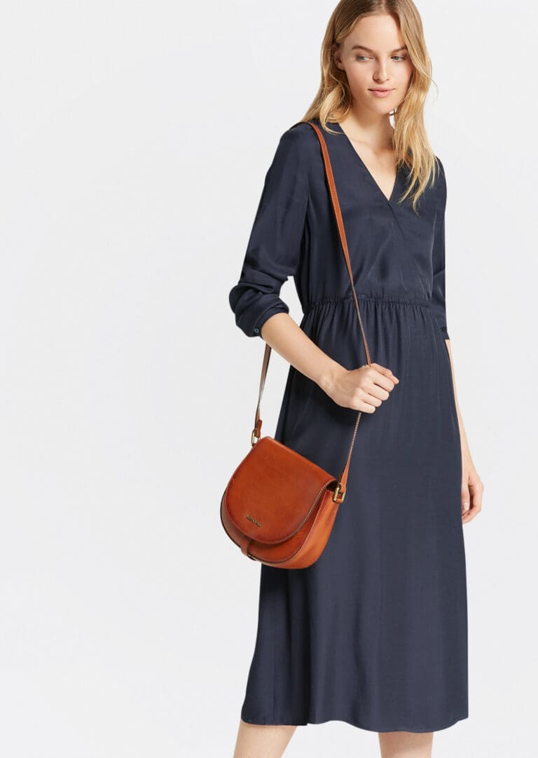 Woman in navy dress with leather crossbody bag