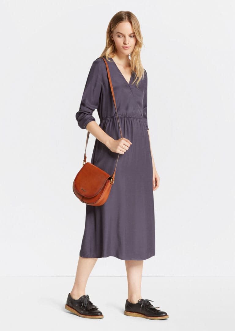 Woman in gray dress with leather crossbody bag