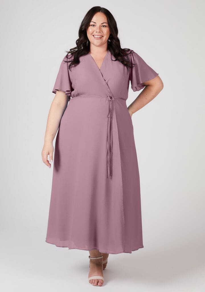 Woman in lavender wrap dress smiling