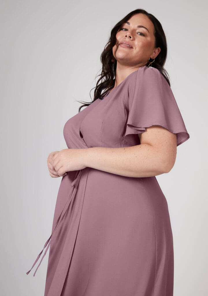 Confident woman in elegant mauve dress smiling