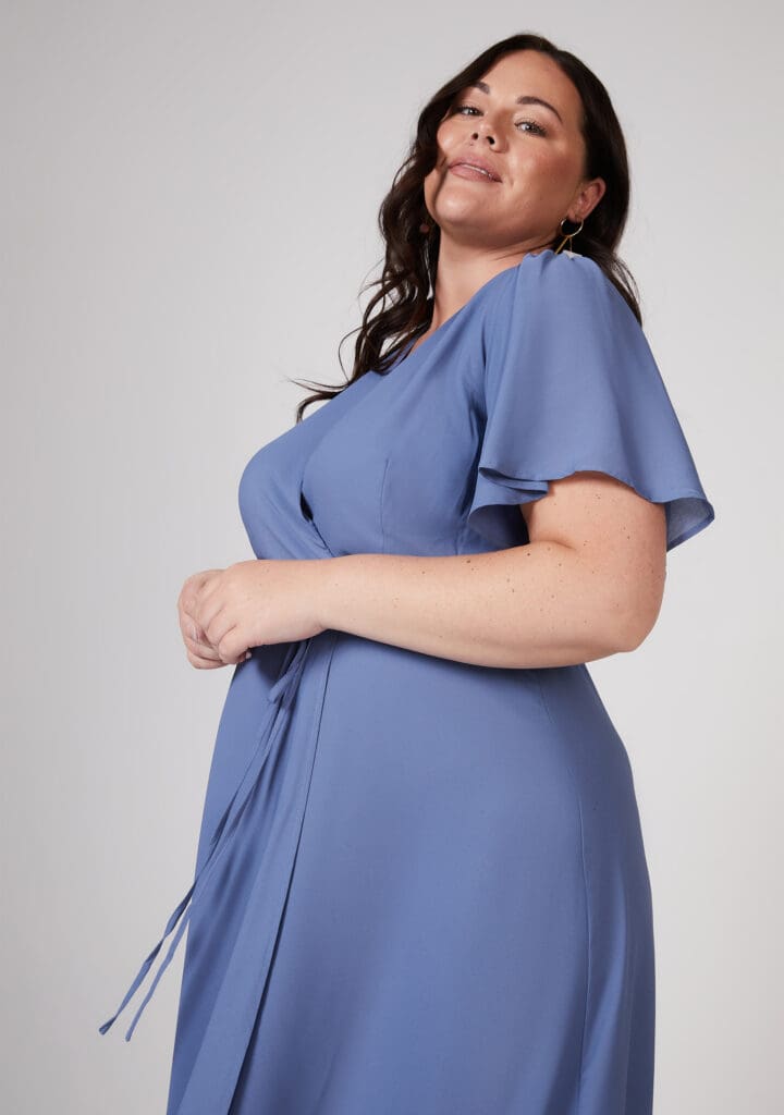 Confident woman in elegant blue dress posing