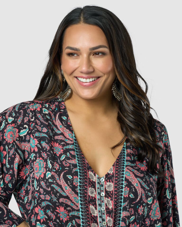 Smiling woman in patterned blouse with earrings