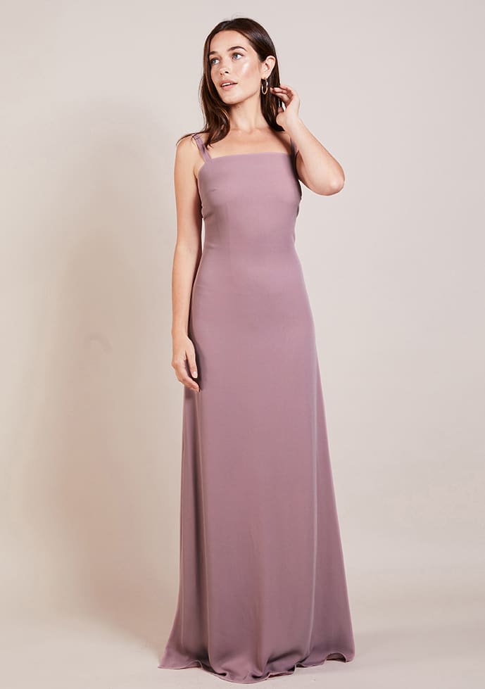 Woman in elegant mauve sleeveless gown posing