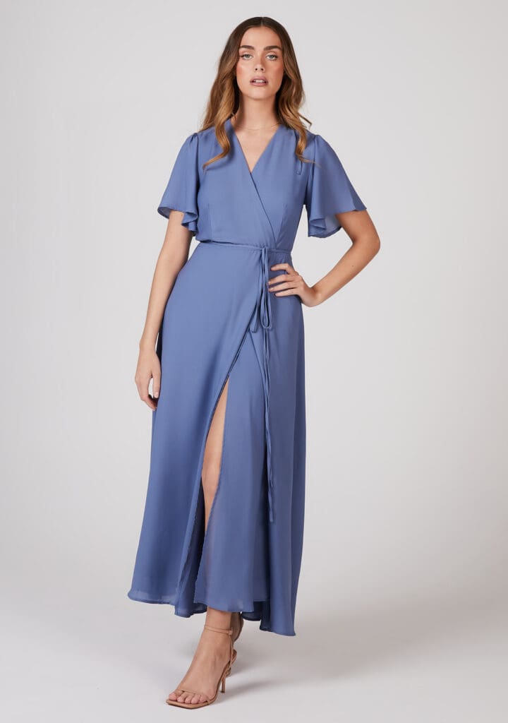 Woman in blue wrap dress with slit and heels