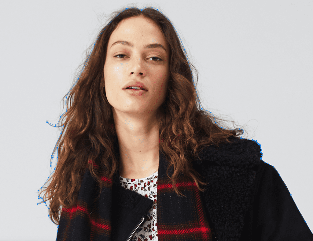 Woman in plaid jacket and floral dress, casual gaze